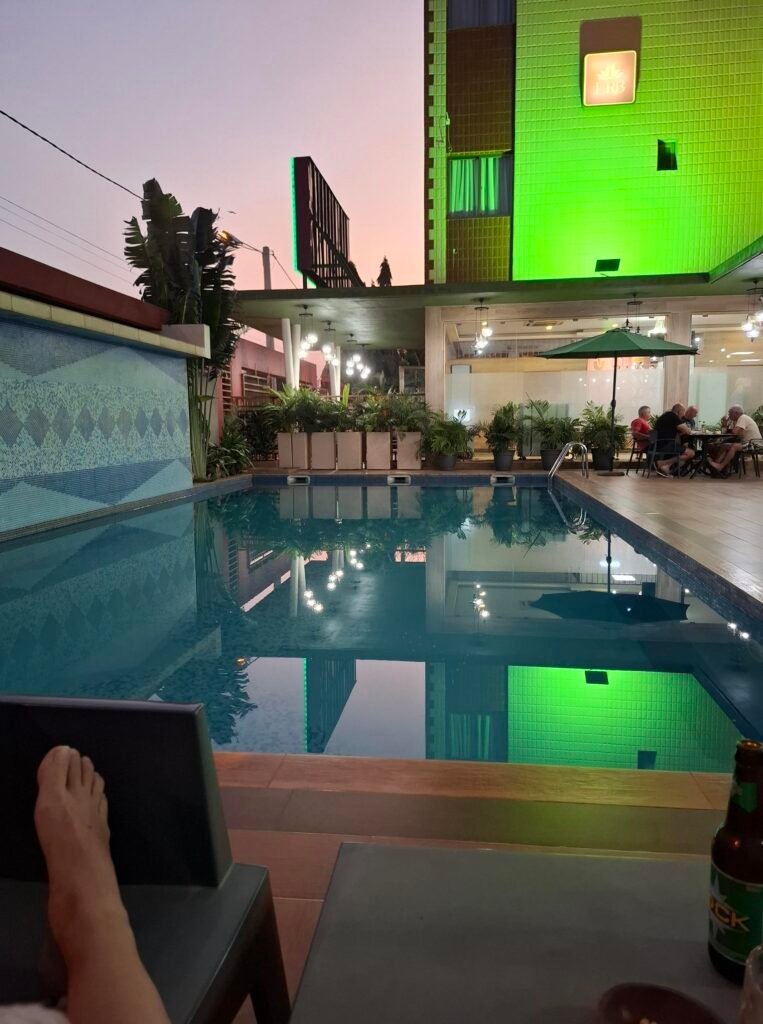 Personne se détendant au bord de la piscine de l’hôtel La Rose Blanche, dans une atmosphère conviviale et ensoleillée.