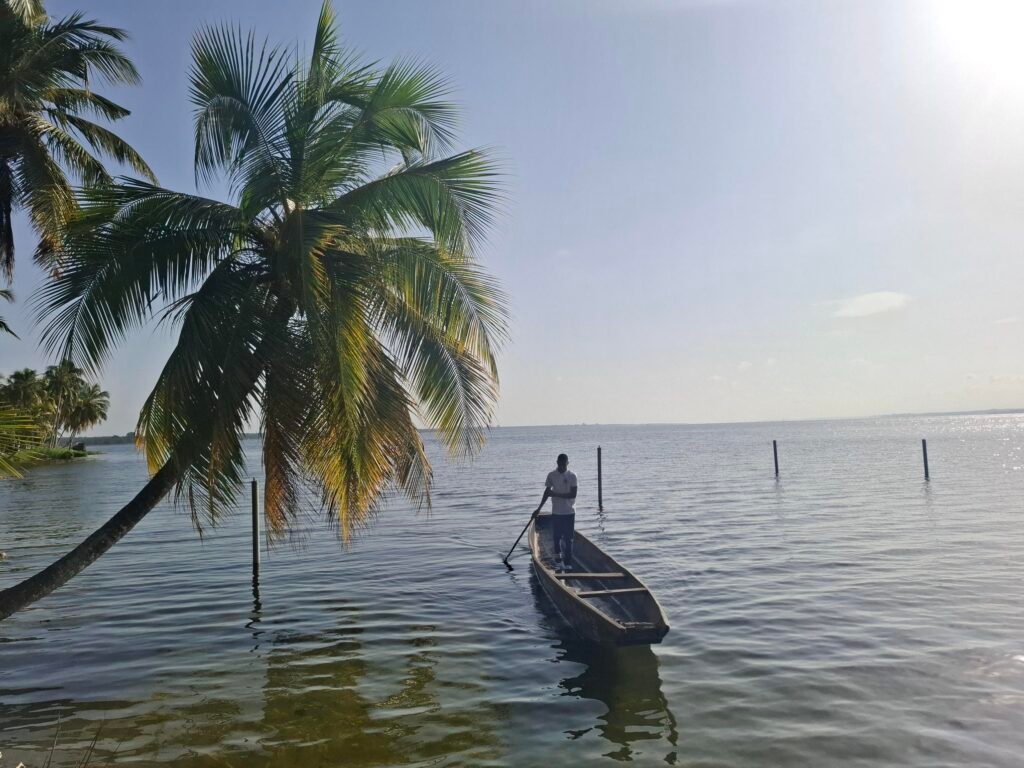 Pirogue traditionnelle flottant sur la lagune Ébrié à Jacqueville, Côte d’Ivoire — scène tranquille illustrant le charme local et la vie au fil de l’eau.