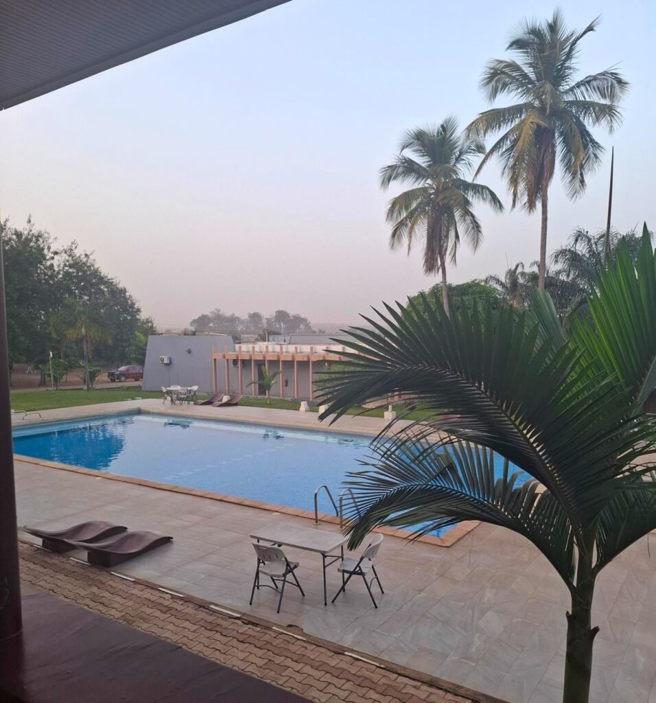 Vue plongeante sur la piscine de l’hôtel Printemps Mont Korhogo, entourée d’un cadre naturel apaisant et d’infrastructures modernes.