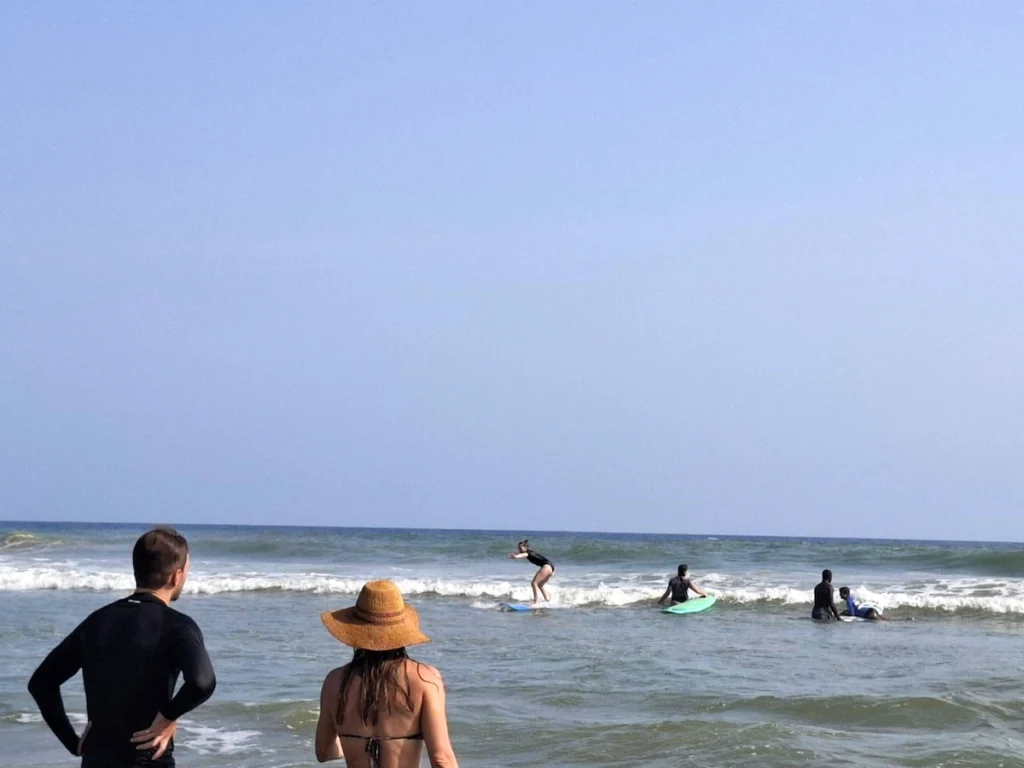 Trois surfeurs sur la plage d’Assinie en Côte d’Ivoire