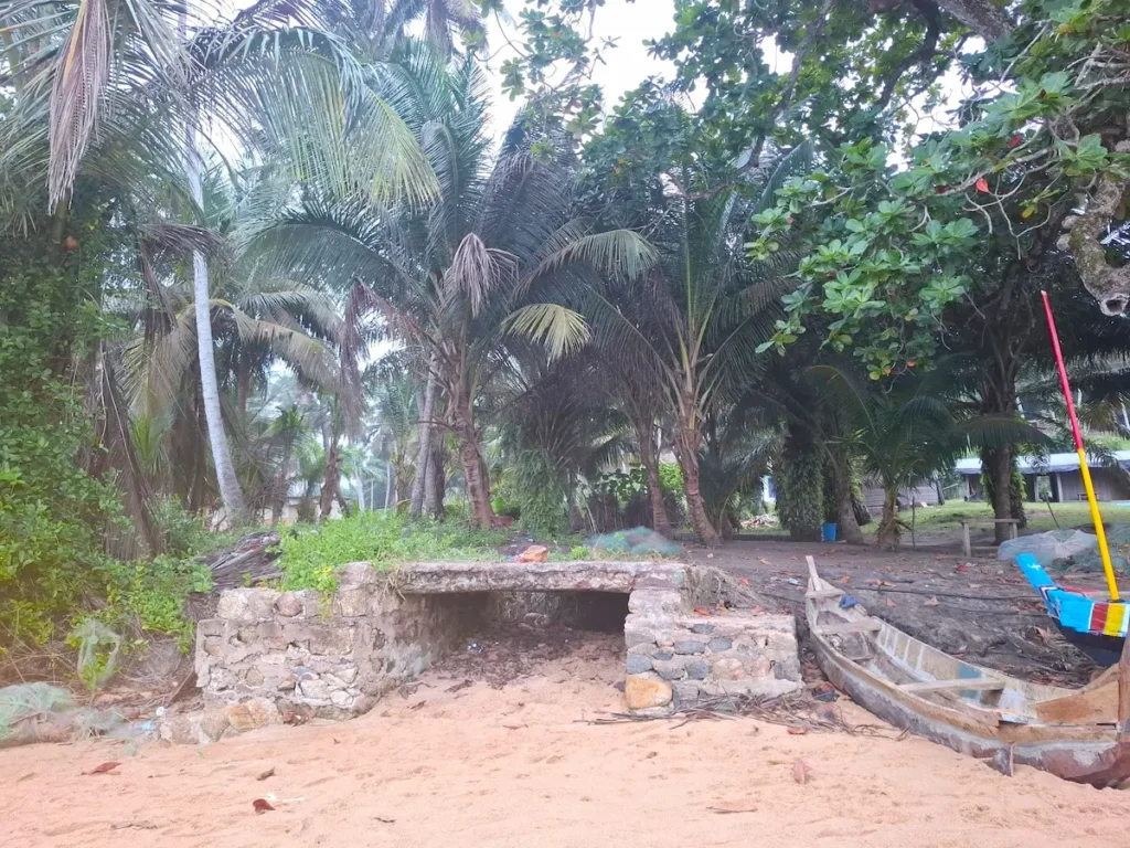 Sortie de l’ancien tunnel des esclaves à Sassandra, entourée de végétation tropicale et de palmiers.