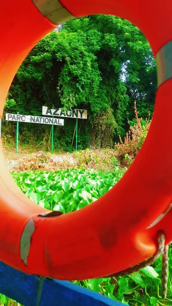 Entrée du Parc national d’Azagny vue à travers un cadre rouge circulaire. 
