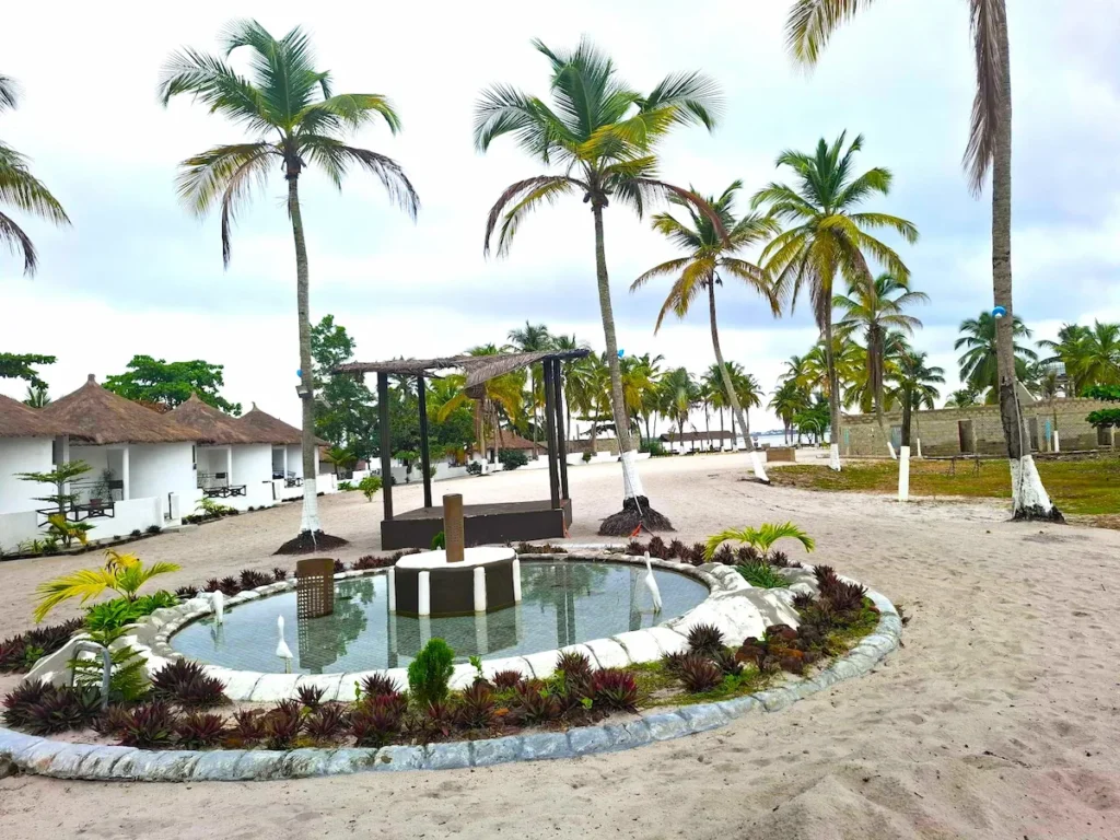 Bungalows de la presqu’île du Christ à Jacqueville, entourés de palmiers et d’un jardin tropical avec un petit étang décoratif.