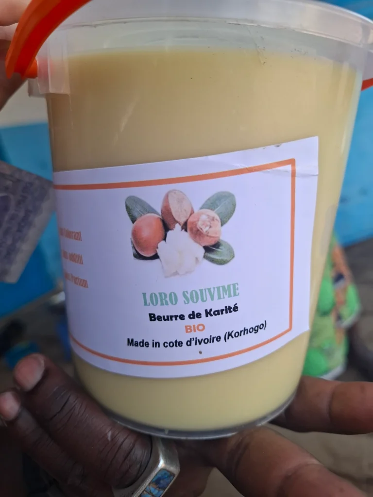 Pot de beurre de karité artisanal de Korhogo, présenté en gros plan.