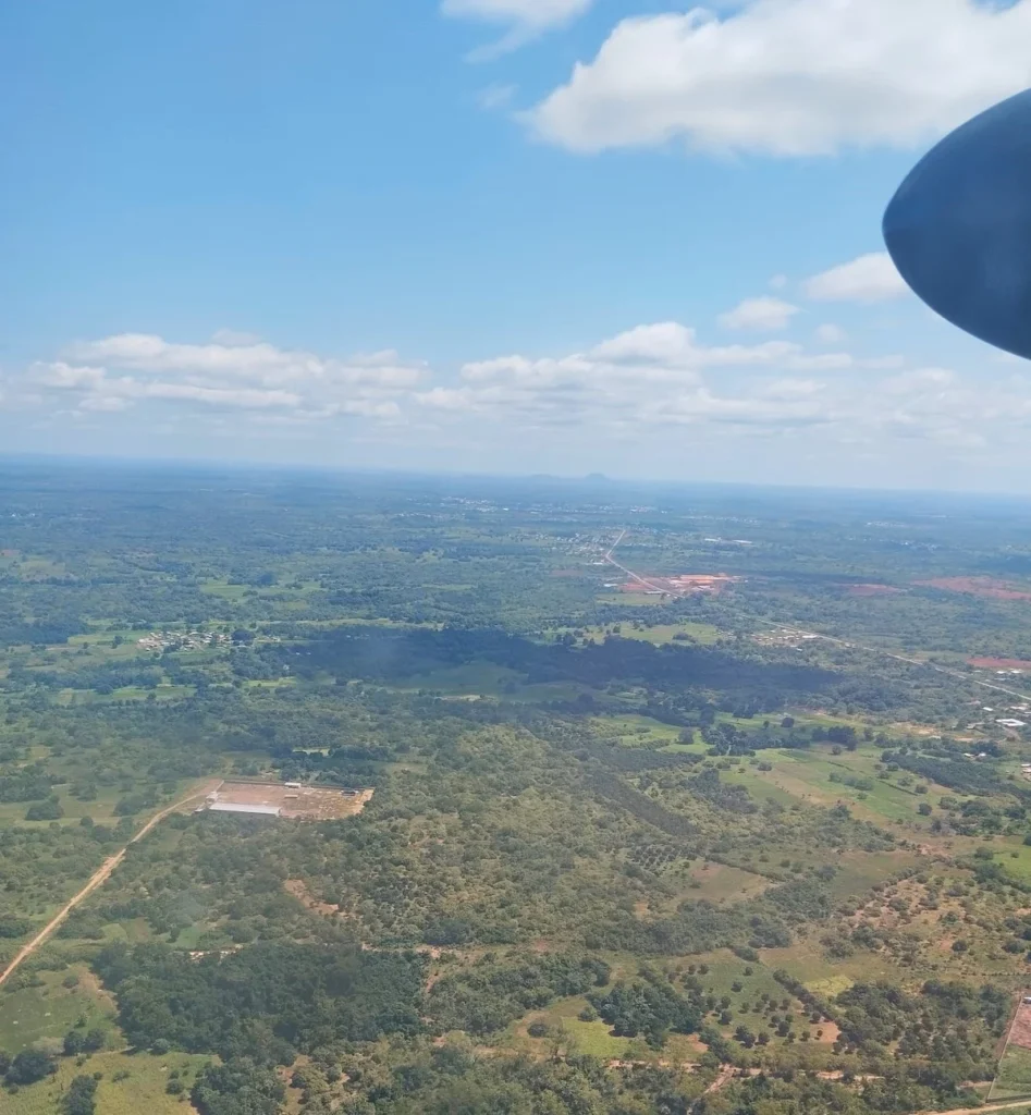 Vue aérienne des environs de Korhogo depuis un avion, avec paysages verdoyants et ciel dégagé. 
