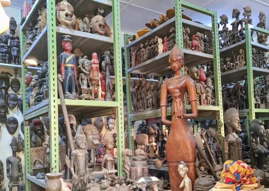 Galerie de masques et d’artisanat traditionnels de Korhogo, avec sculptures en bois et décorations ivoiriennes exposées sur des étagères.