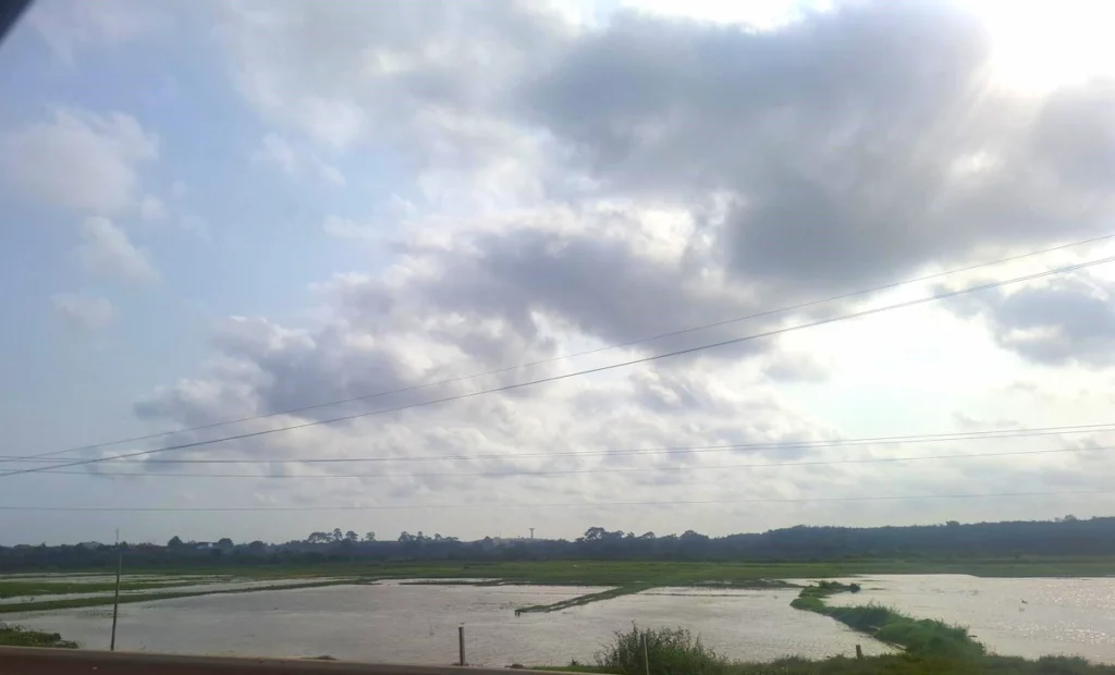  Vue de la lagune de San Pedro en Côte d’Ivoire avec ciel nuageux et reflets sur l’eau. 