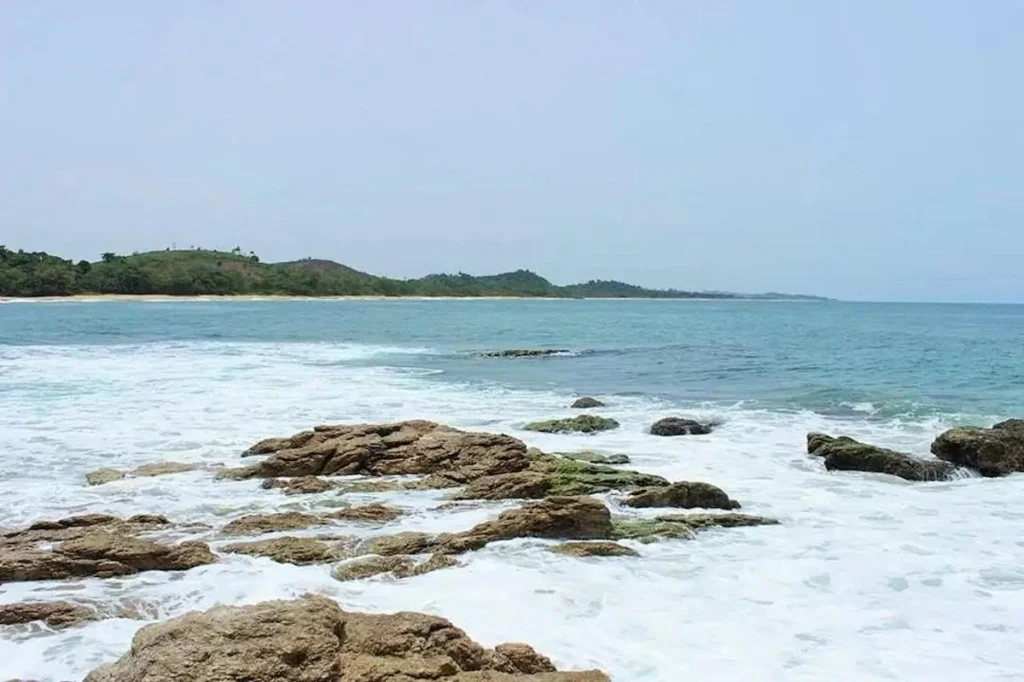 La Pointe de Taki à San‑Pedro, Côte d’Ivoire : grande baie protégée, rochers en premier plan et eau turquoise.