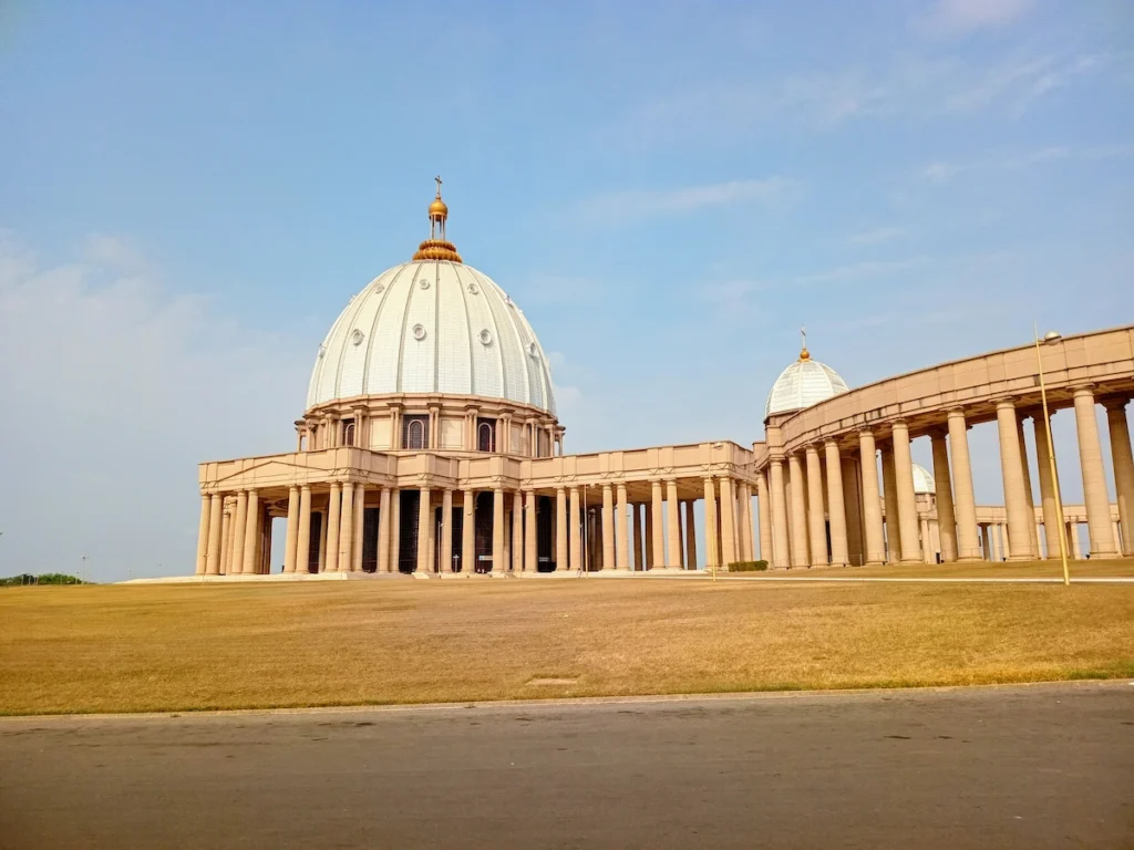 Basilique Notre‑Dame de la Paix à Yamoussoukro sous un ciel bleu, vue depuis l’esplanade.