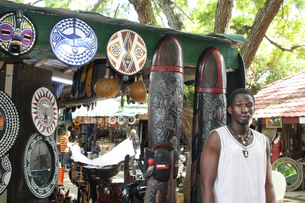Artisanat ivoirien à Abidjan avec masques et sculptures traditionnels Marché artisanal d’Abidjan avec masques colorés et sculptures ivoiriennes, symbole de l’art local