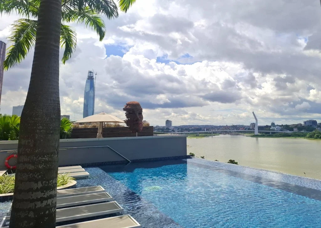 Vue panoramique depuis le rooftop du Noom Hotel sur le Plateau, la lagune Ébrié et le pont d’Abidjan Piscine infinity du Noom Hotel à Abidjan avec vue sur la lagune Ébrié, la Tour F et le pont du Plateau