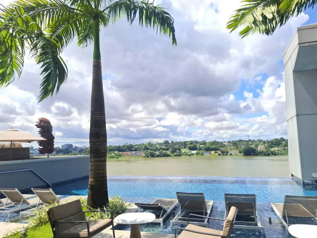 Vue sur la lagune et piscine depuis le rooftop de l'hôtel Noom, une option moderne où dormir à Abidjan