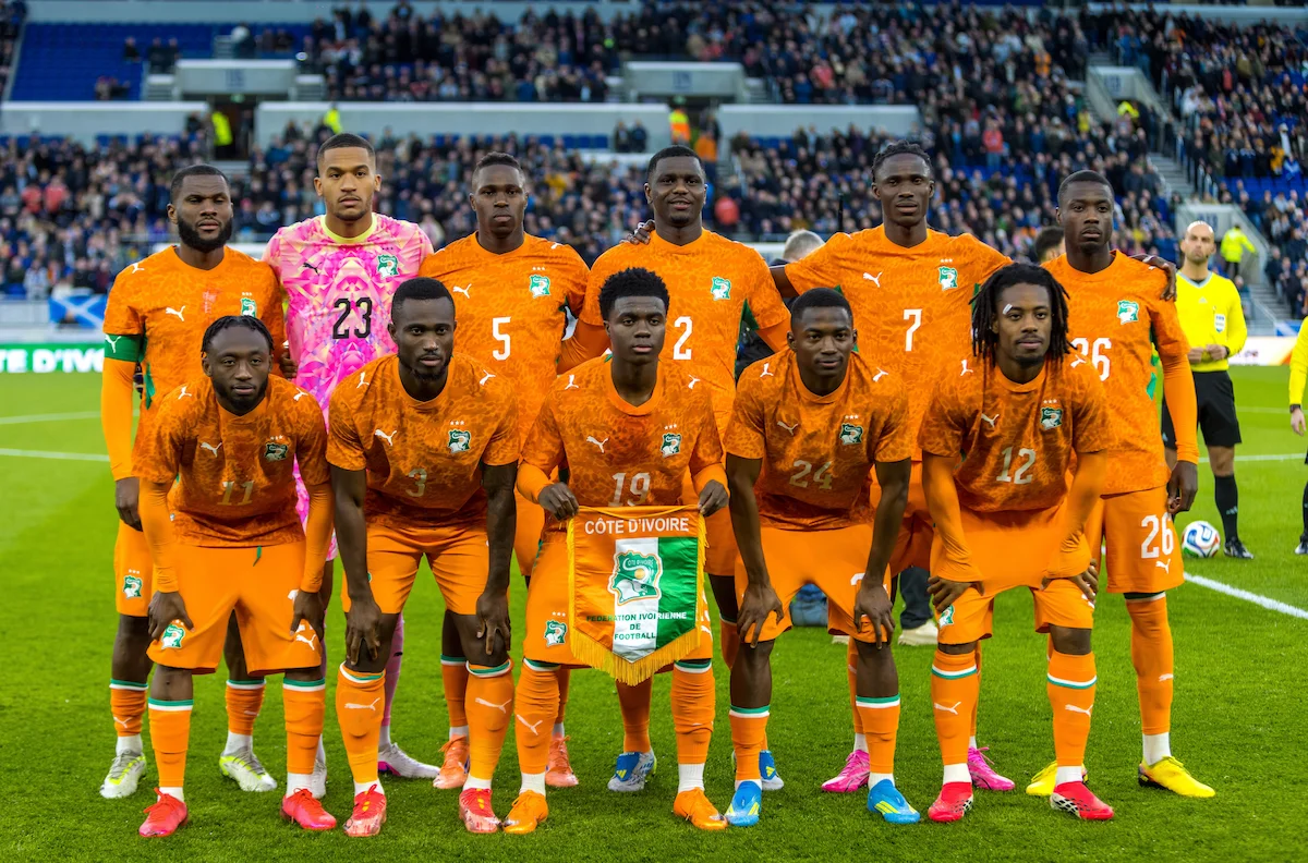 Alignement de départ de la Côte d’Ivoire au Hill Dickinson Stadium à Liverpool, joueurs en maillot orange avant le match du 31 mars 2026, avec le stade plein en arrière‑plan.